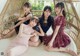 A group of young women sitting on top of a bed.