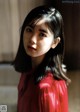 A woman in a red blouse poses for a picture.